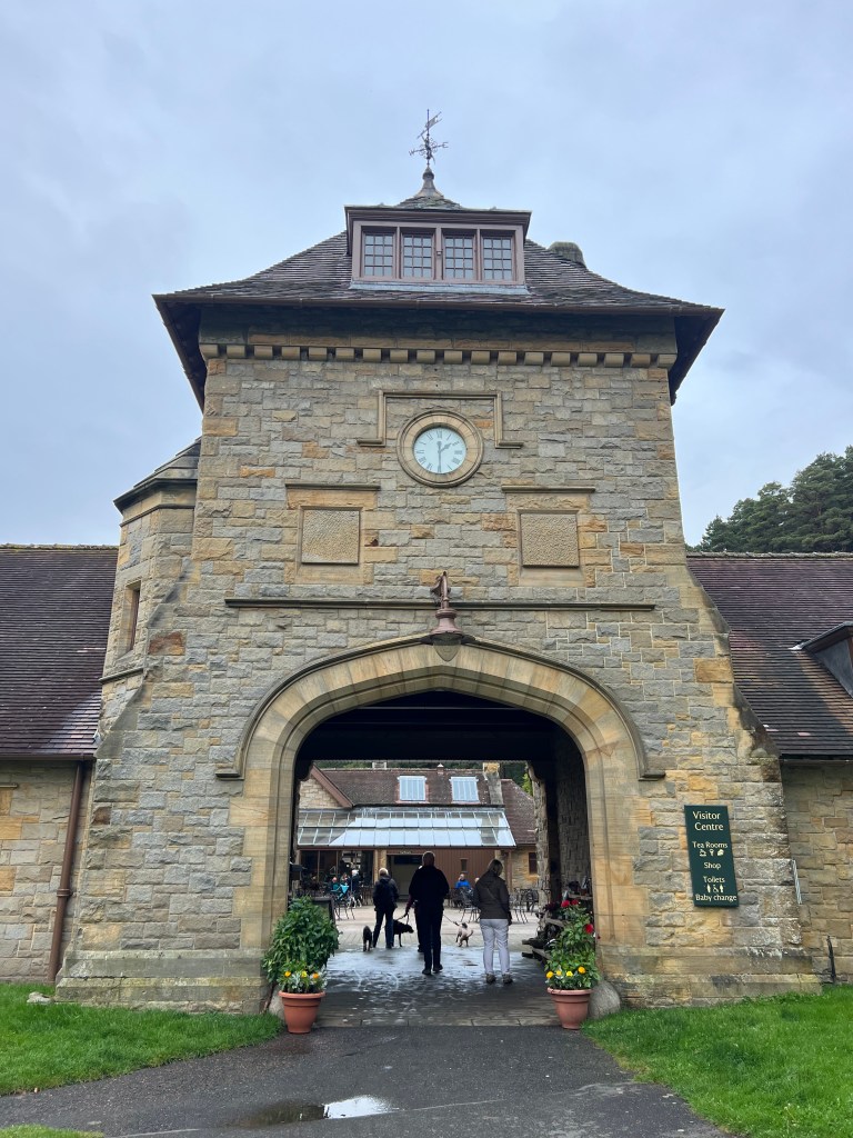 The archway entrance to the stables at Cragside with a clock tower above the archway. 