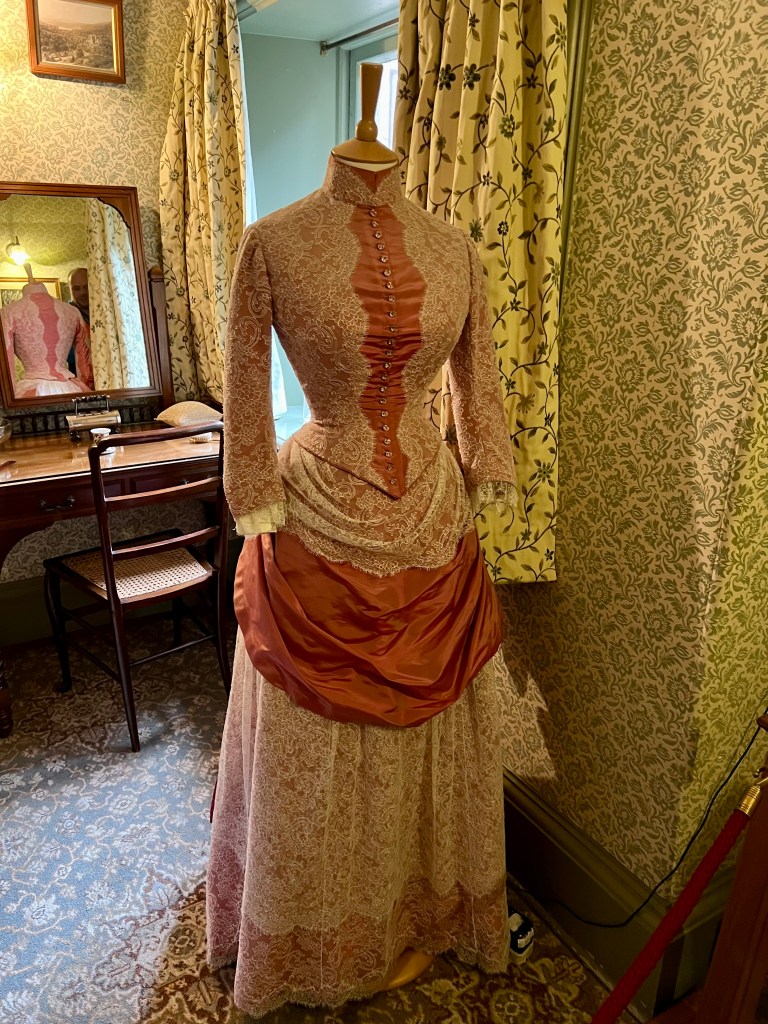 A dressmakers dummy wearing a pink floral skirt and top.