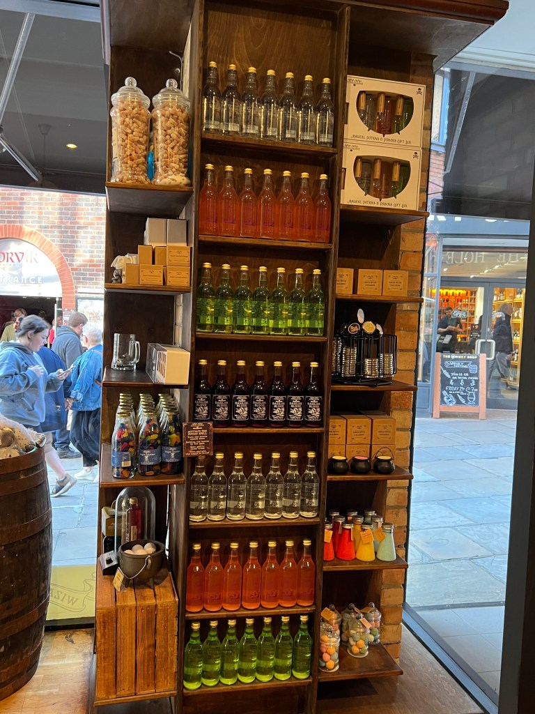 Photo shows shelves full of bottles of drinks of different colours and bottles and boxes full of sweets. 