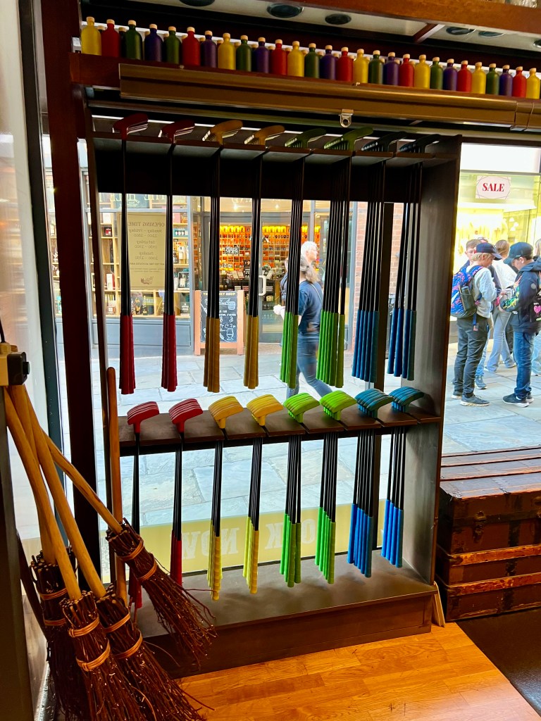 The photo shows a large rack in front of a window with two rows of crazy golf clubs with red, yellow. green or blue handles. 