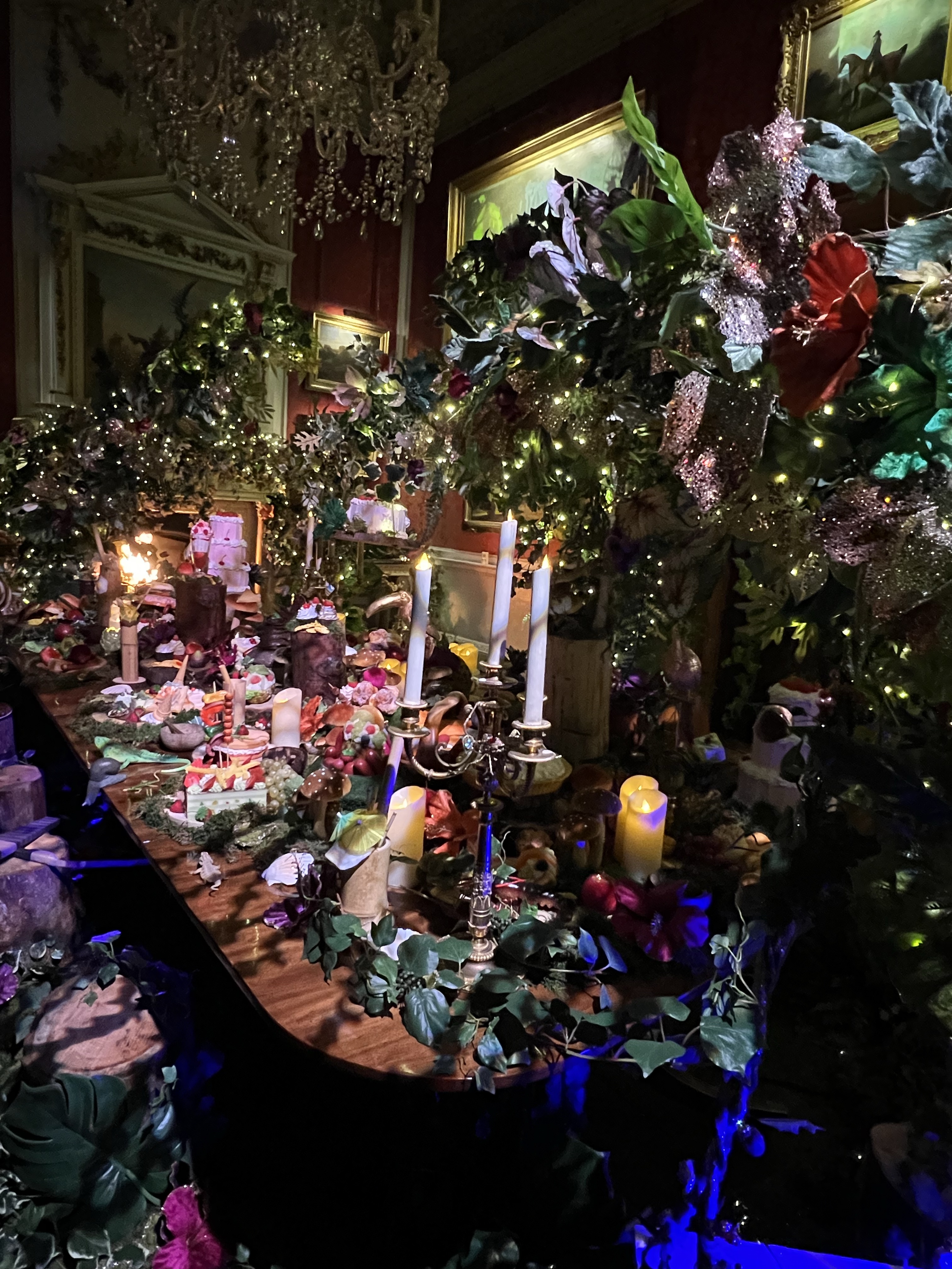 The dining room set for a feast for the lost boys with foliage, candles and fake food. 