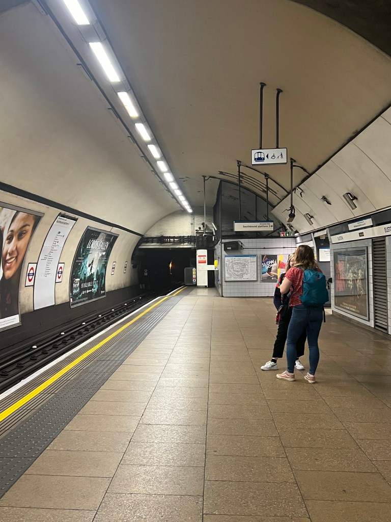 A tube platform with 2 people stood on it looking away from the camera.