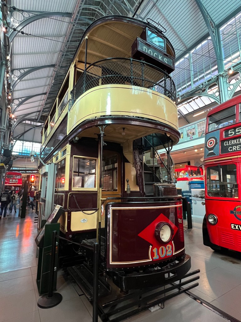 A double decker brown and cream tram. 