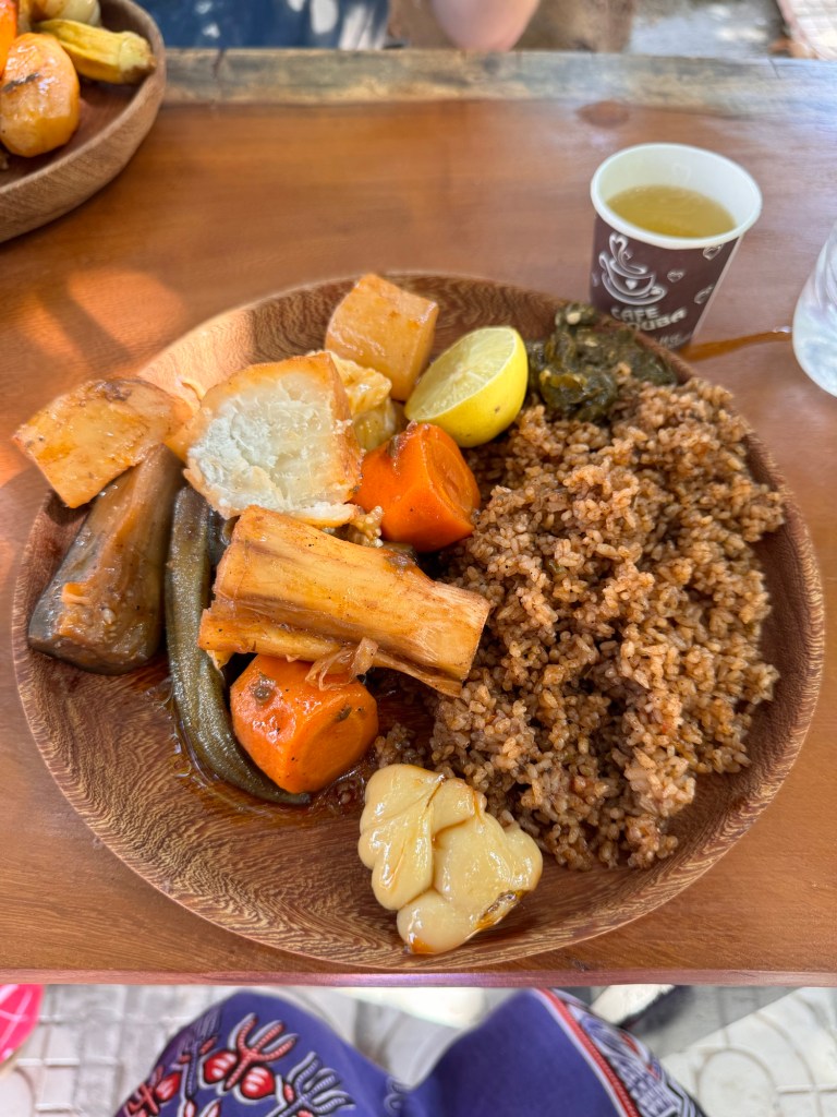 A plate of benechin, with Gambian rice and vegetables a wooden plate. 