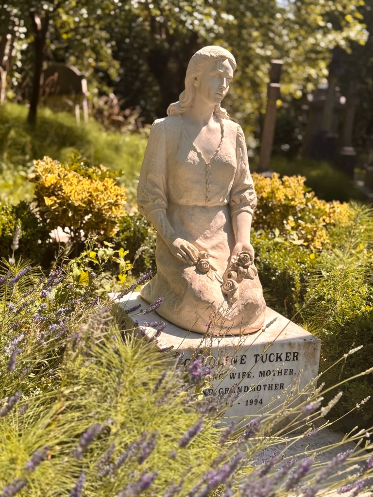 A grave stone in the shape of a lady praying. 