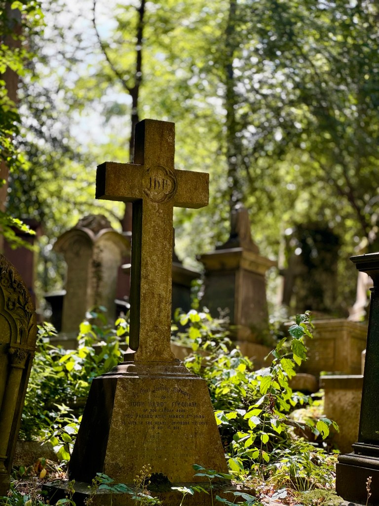 A gravestone in the shape of a cross. 